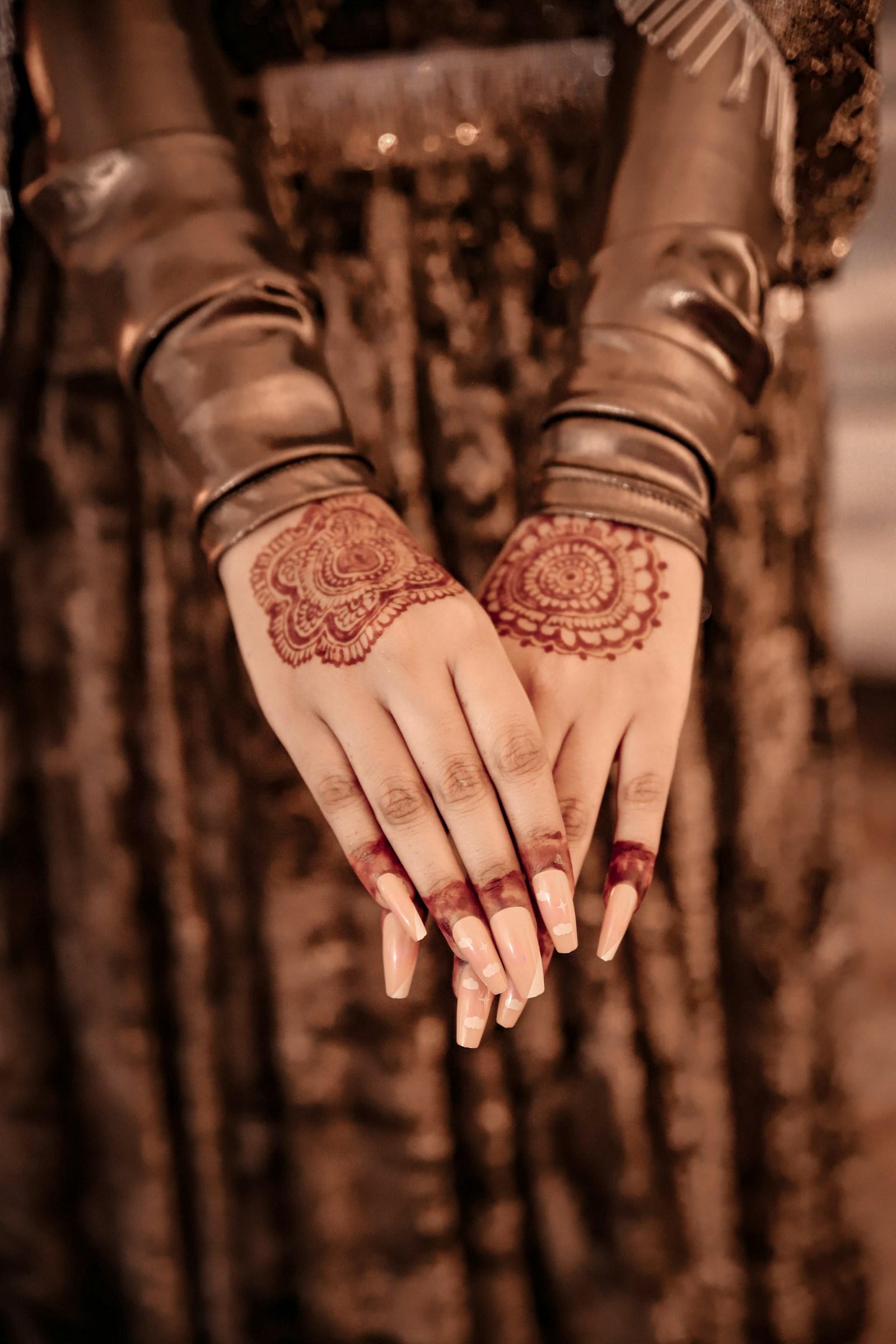 Fresh mehndi drying on a bride’s hands, bronze bangles catching the light